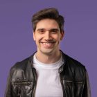 Headshot of friendly man smiling, confident happy stylish guy portrait on violet studio. High quality